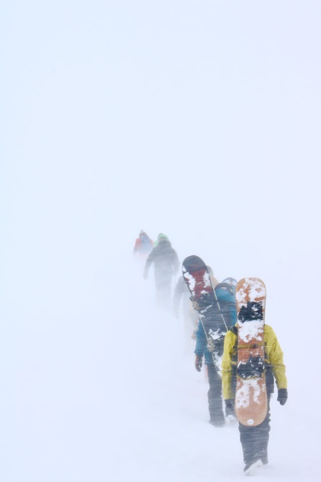 Spitboarders hike in the snowstorm