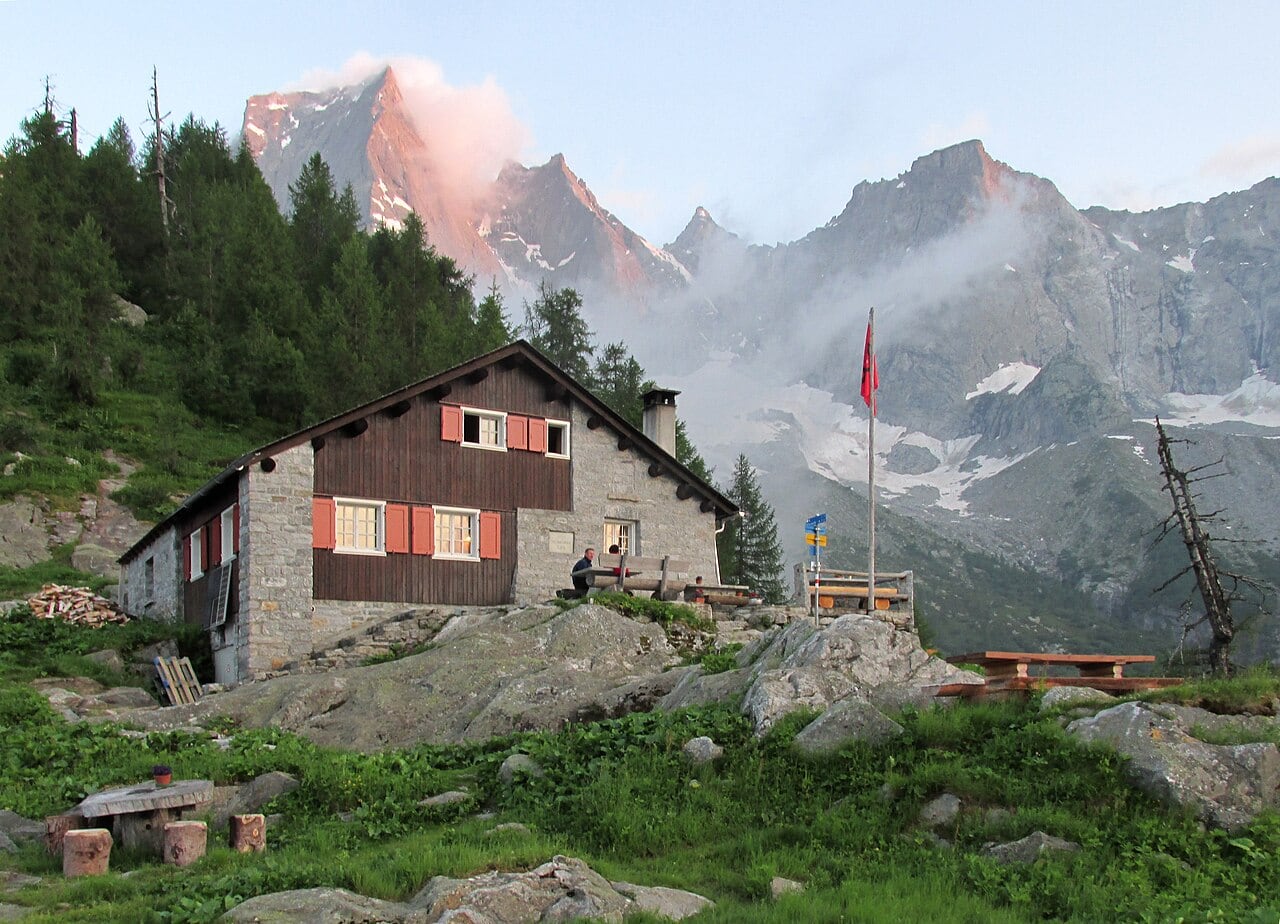 Die Capanna Sasc Furä Hütte mit dem Piz Badile im Hintergrund