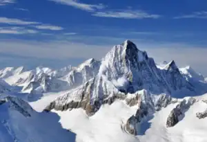 Steile Felspyramide des Finsteraarhorns über weiten Gletscherbecken unter blauem Himmel