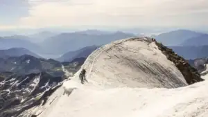 Firnkuppe des Weissmies mit felsigem Gipfelgrat über gestaffelten Bergketten