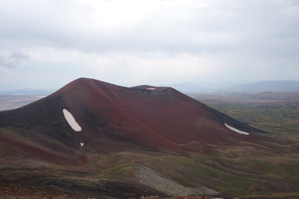 Roter Vulkankegel mit Schneeresten im armenischen Geghama-Gebirge