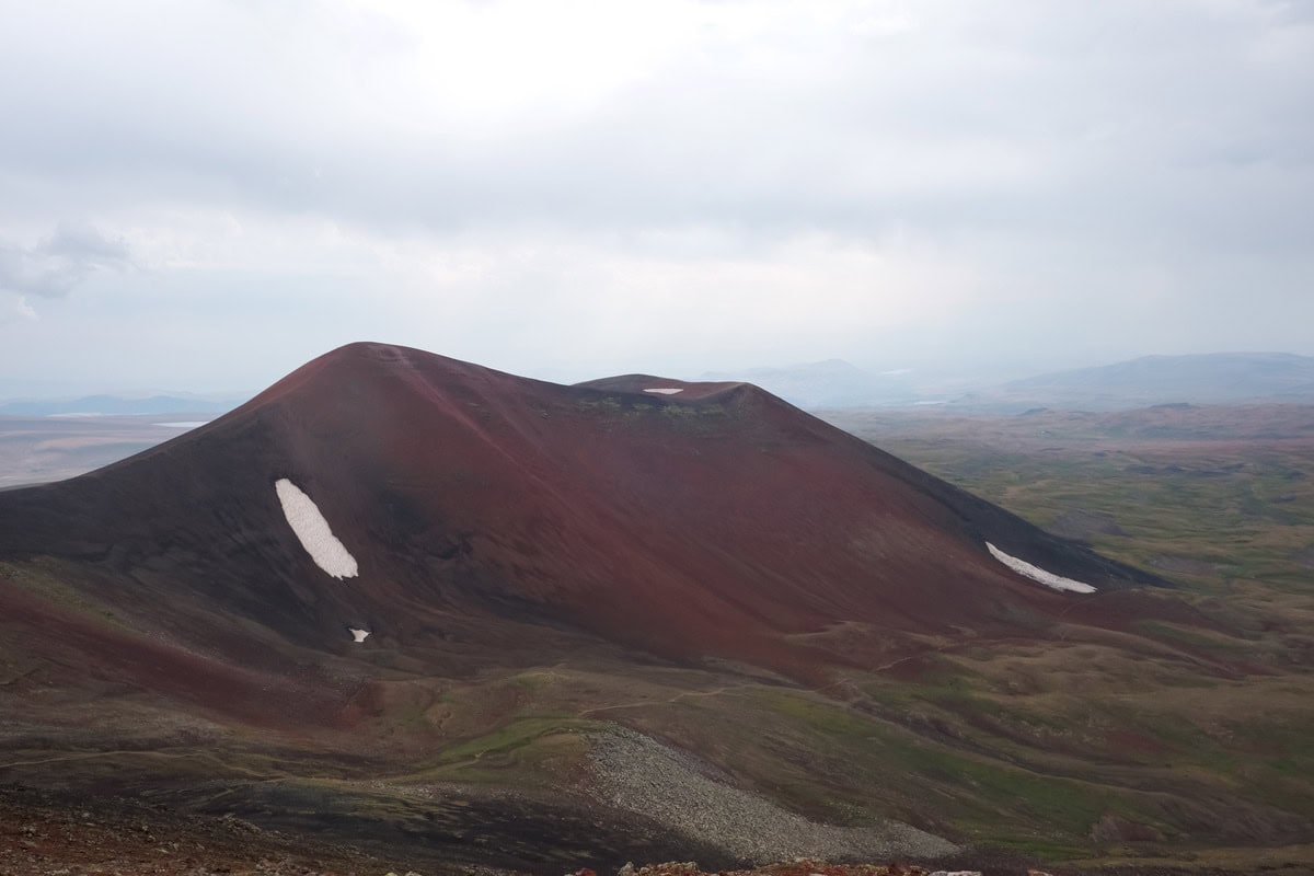 Roter Vulkankegel mit Schneeresten im armenischen Geghama-Gebirge
