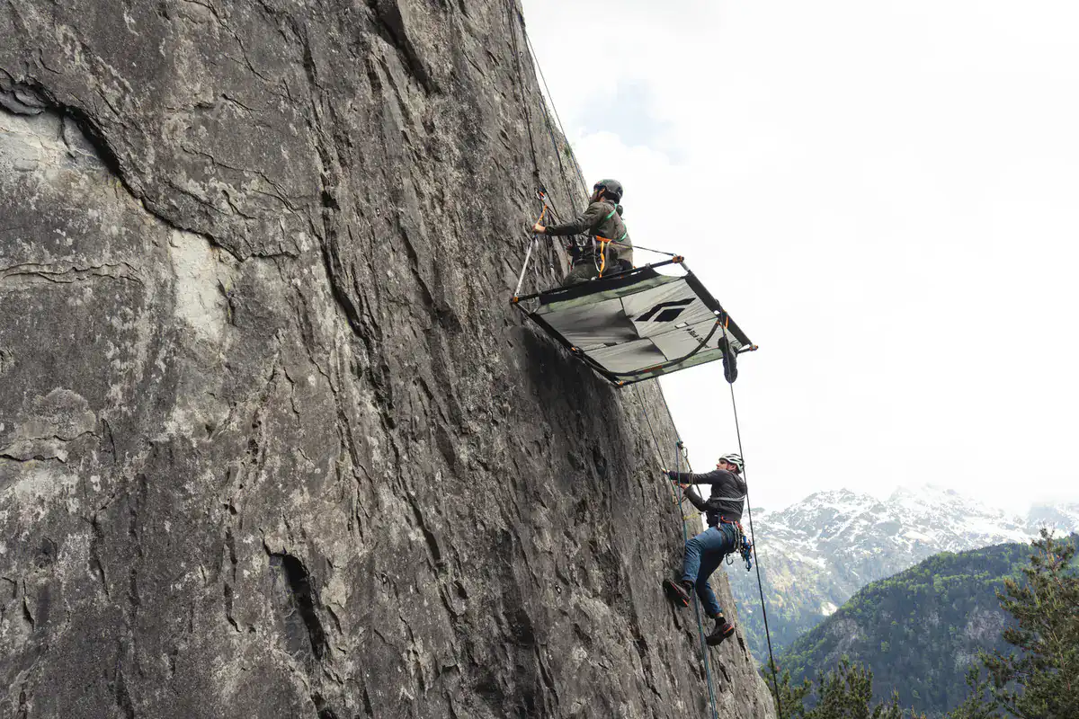 Zwei Kletterer mit aufgebautem Portaledge an einer Felswand