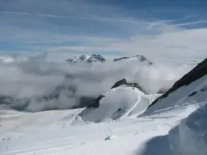 Gletscherskigebiet über dem Nebelmeer mit Blick auf verschneite Gipfel