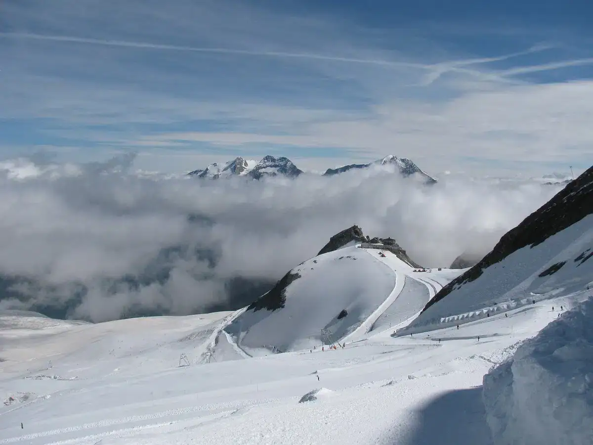 Gletscherskigebiet über dem Nebelmeer mit Blick auf verschneite Gipfel