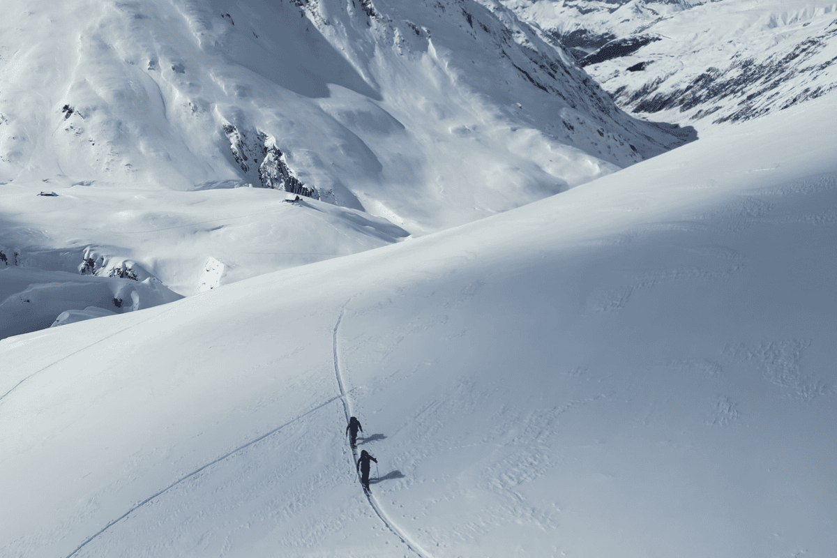 Skitourengeher im Aufstieg über einen verschneiten Hang