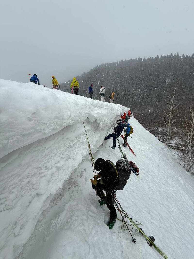 Ausbildungsgruppe übt Seiltechnik an einer steilen Schneeflanke