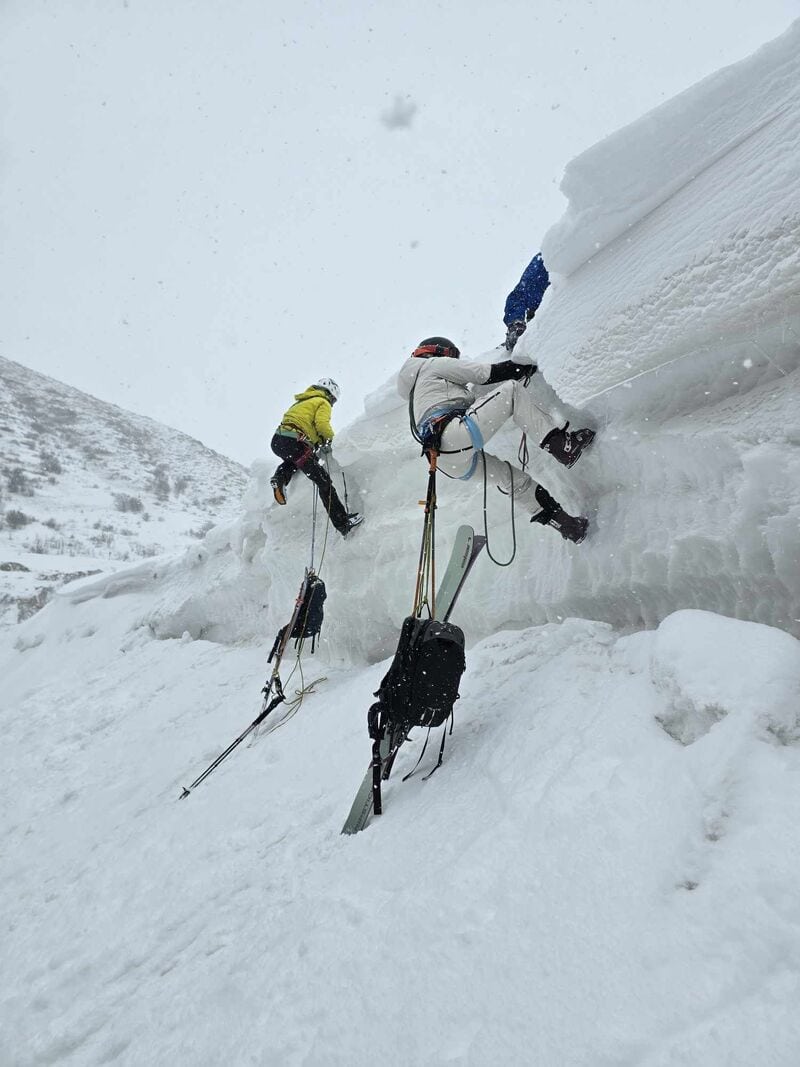 Zwei Personen üben den Aufstieg an einer Eis- und Schneewand