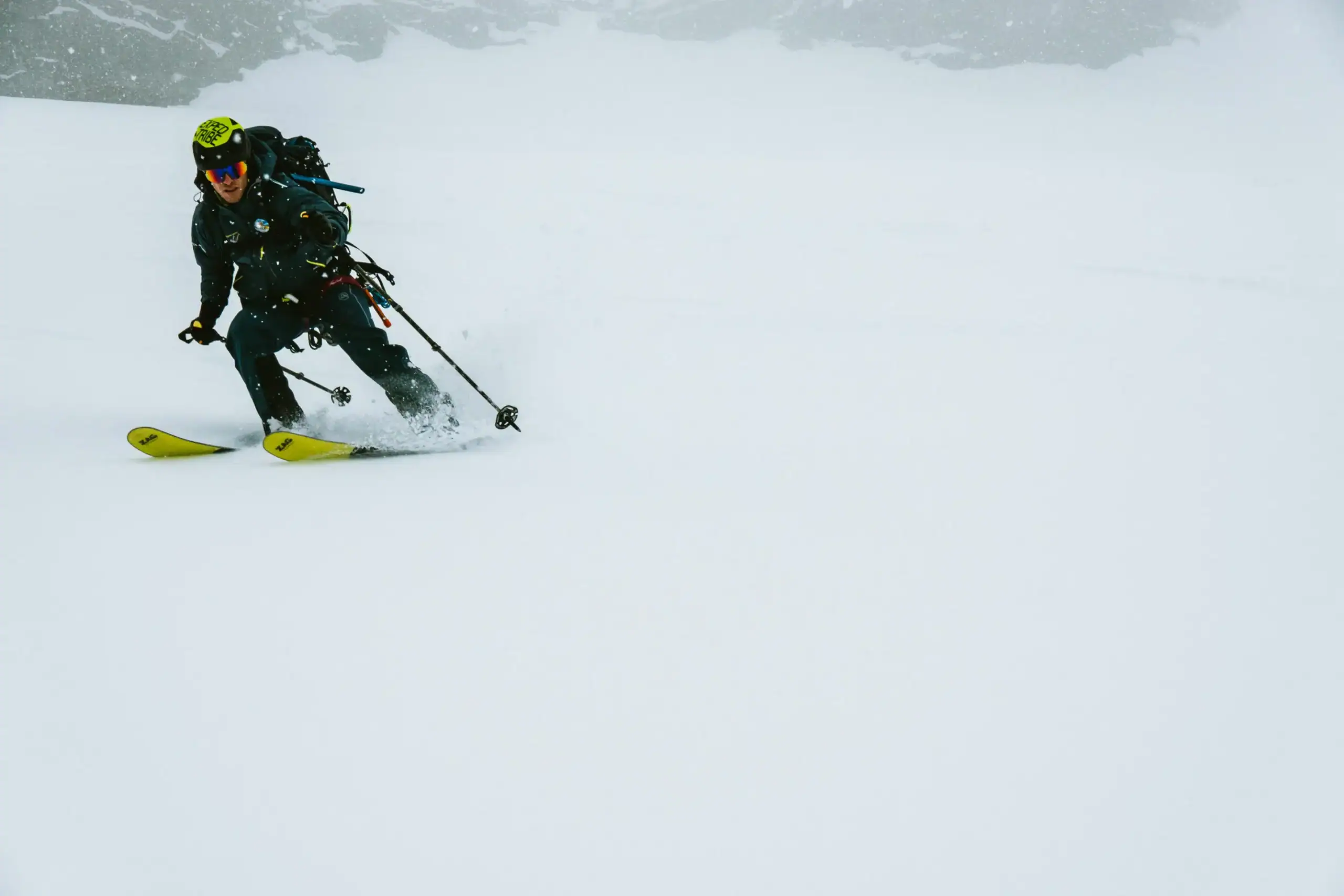Skitourengeher bei der Abfahrt im diffusen Licht mit Tourenrucksack