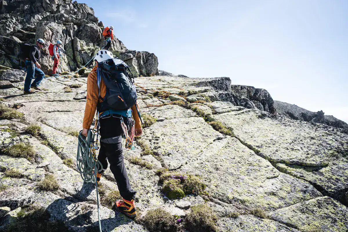 Alpinisten im Aufstieg über plattigen Fels am Grat