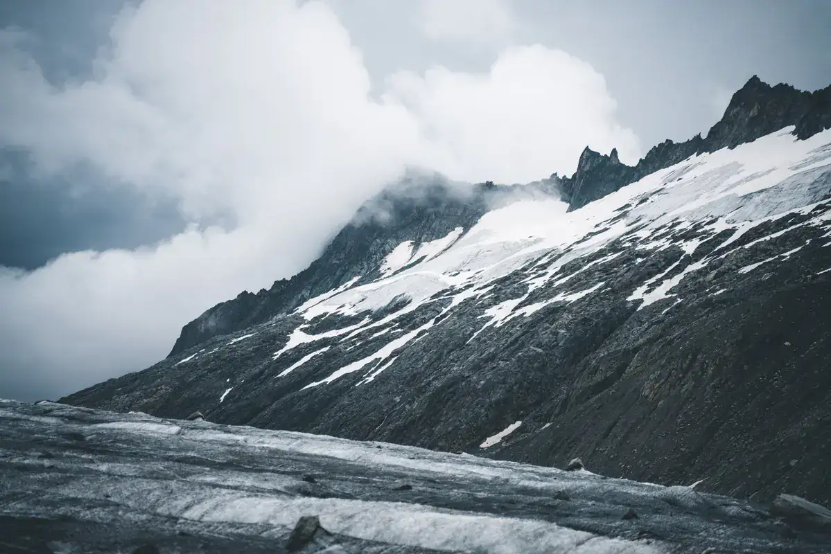 Verschneiter Felsgrat über einem Gletscher, Wolken am Grat