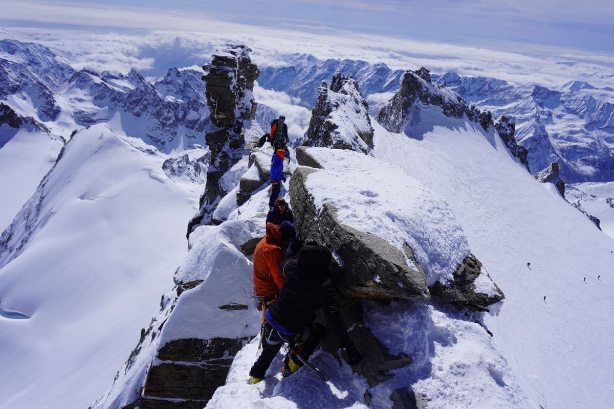 Seilschaft auf dem verschneiten Felsgrat kurz unter dem Gipfel des Gran Paradiso