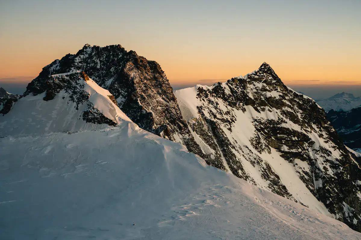Zwei Felsgipfel im Monte-Rosa-Gebiet im Abendlicht über einem Firngrat