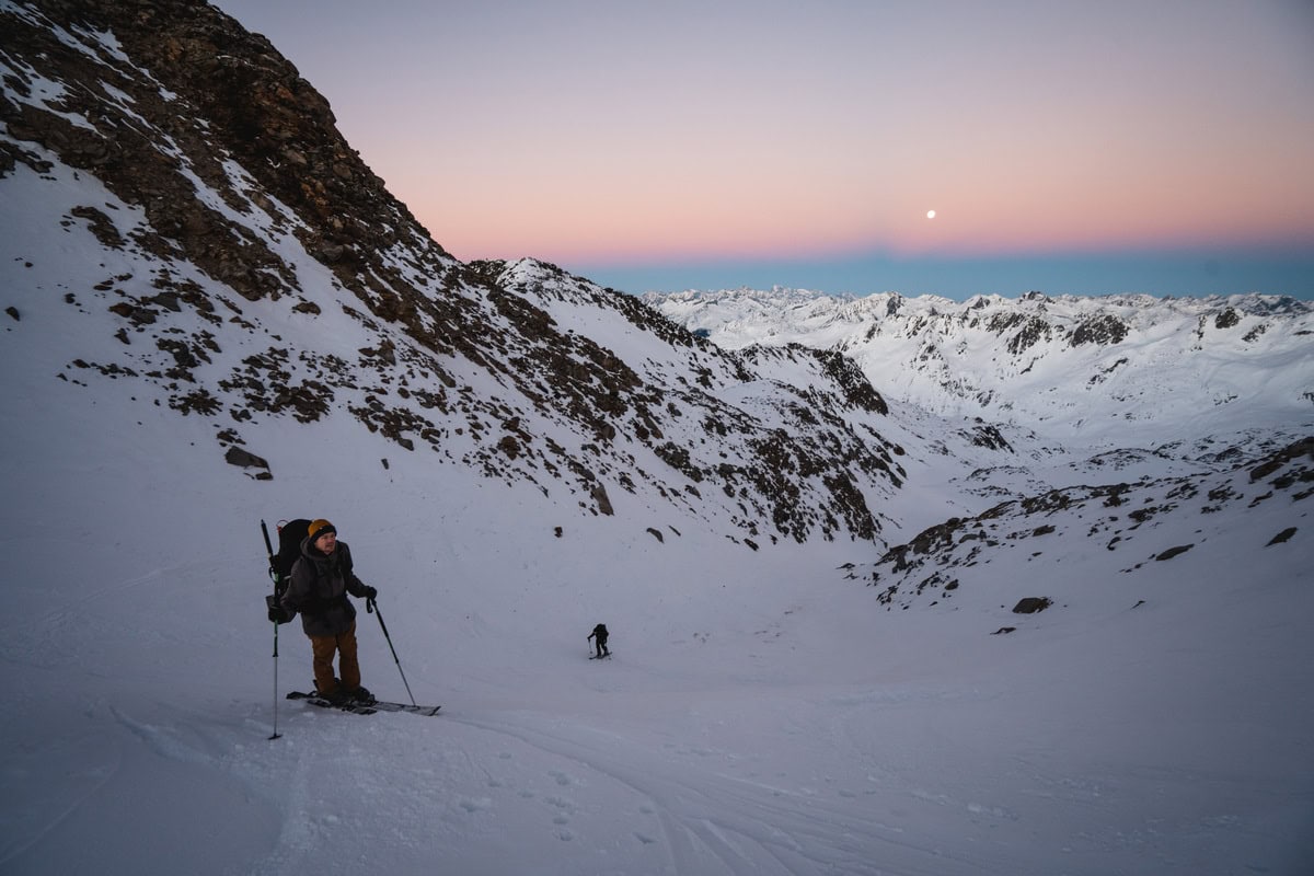 Skitourengeher im Aufstieg durch ein Couloir bei Mondaufgang