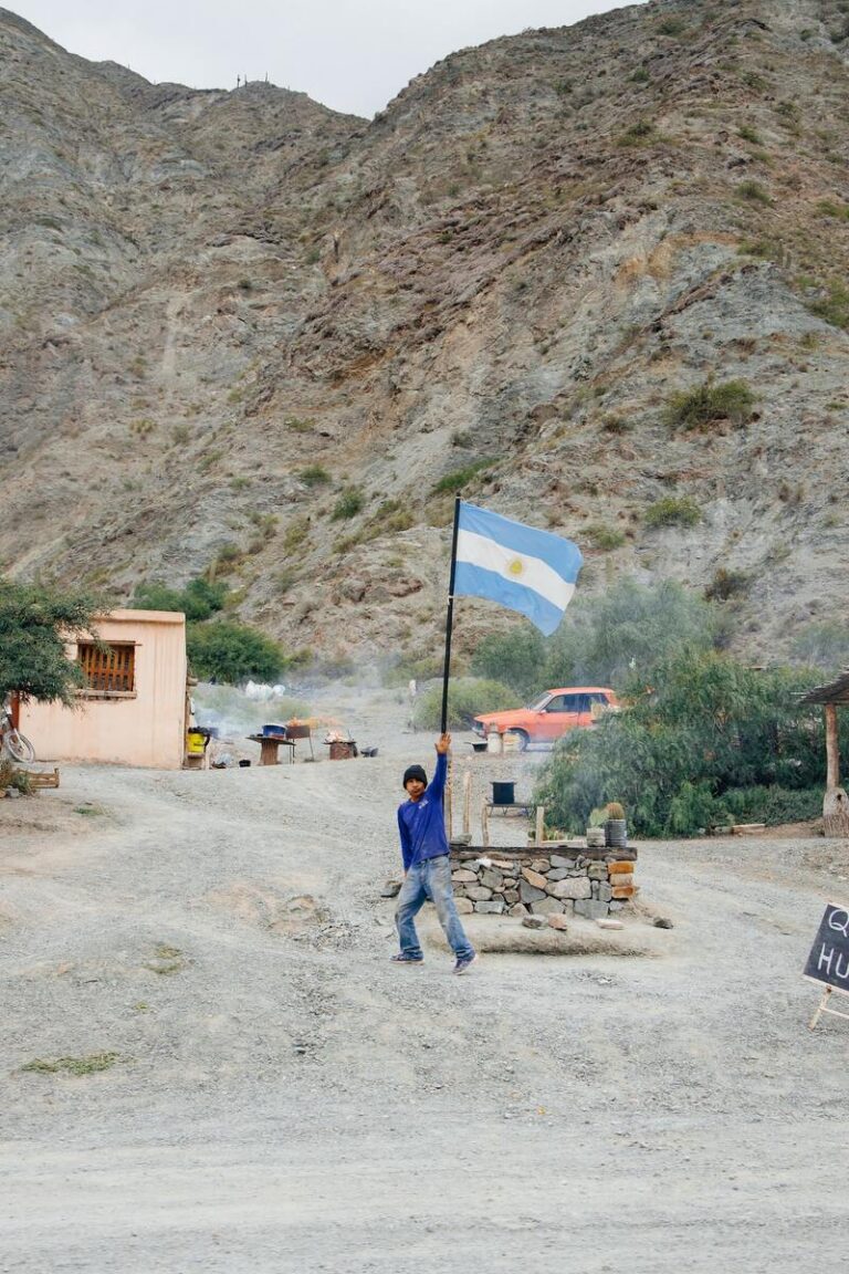 Argentinische Flagge über einem Kontrollposten in einem staubigen Bergtal