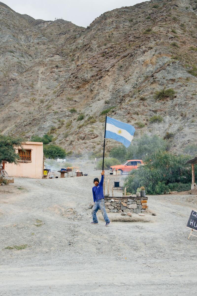 Argentinische Flagge über einem Kontrollposten in einem staubigen Bergtal