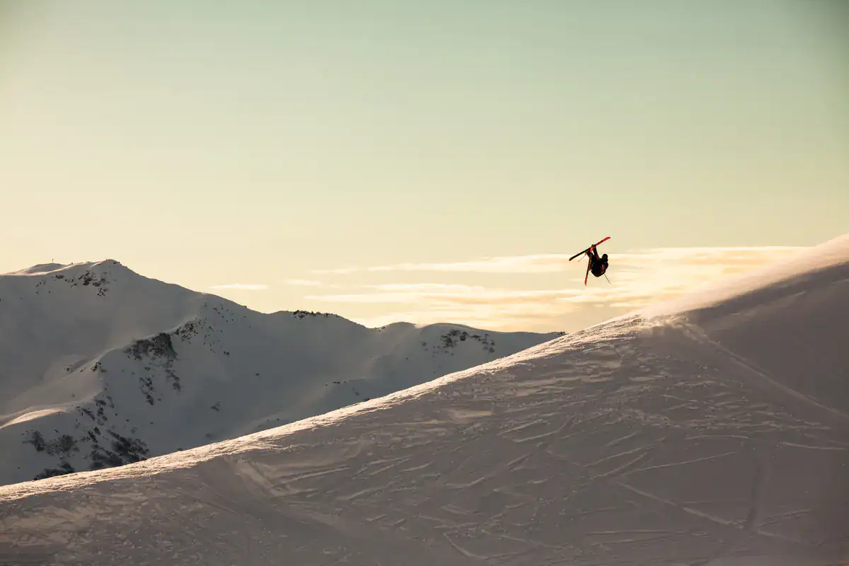 Freerider springt über einen Backcountry-Kicker im Abendlicht