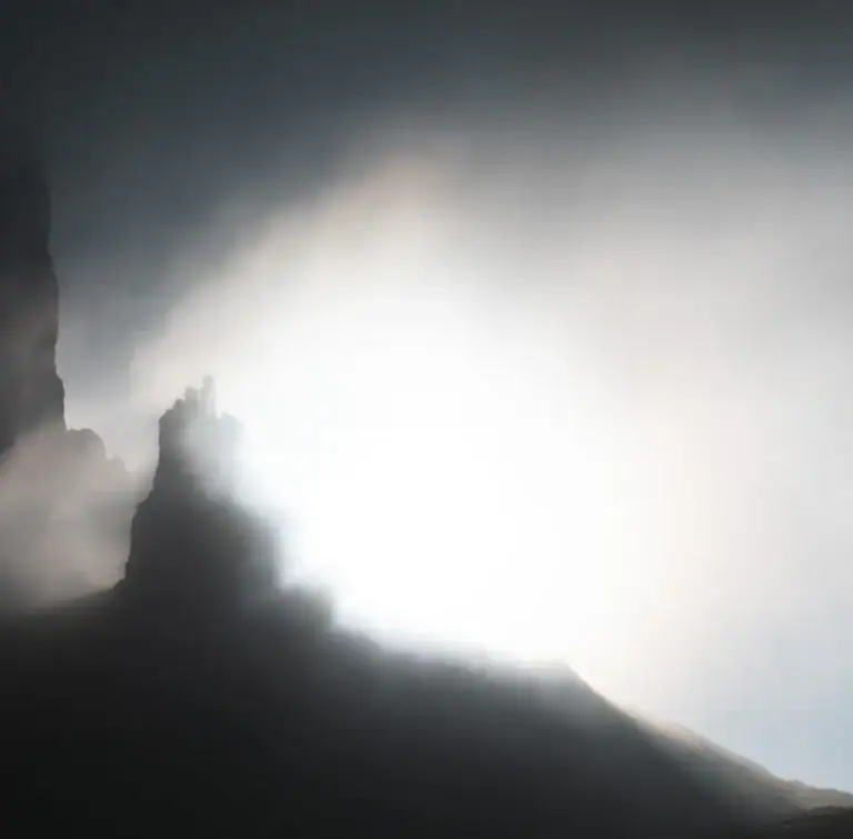 Felsturm im Gegenlicht, umflossen von dichtem Nebel