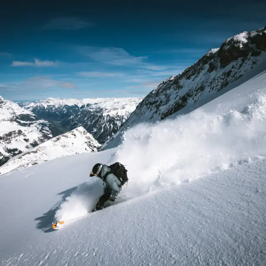 Freerider zieht eine Powderspur durch einen verschneiten Steilhang