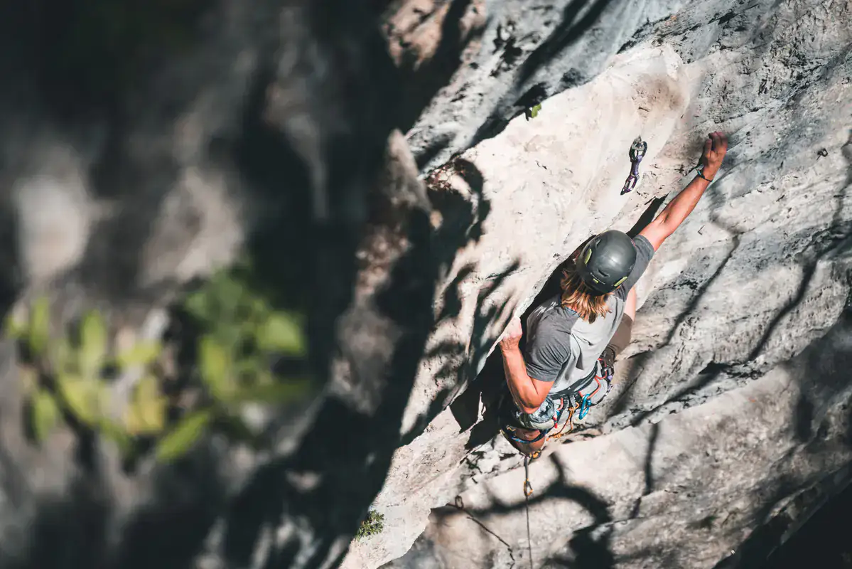 Kletterin im Vorstieg an einer Felswand