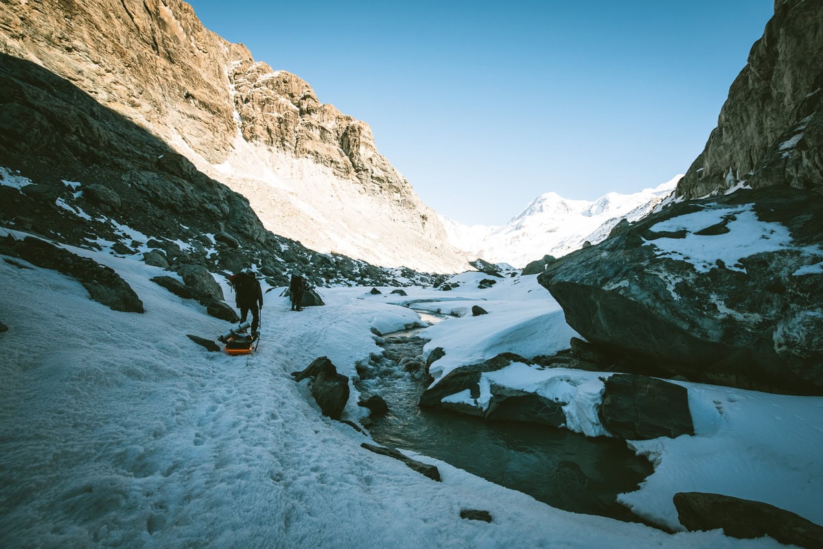 Gefrorener Flusslauf zwischen steilen Felswänden in einer winterlichen Schlucht in Ladakh