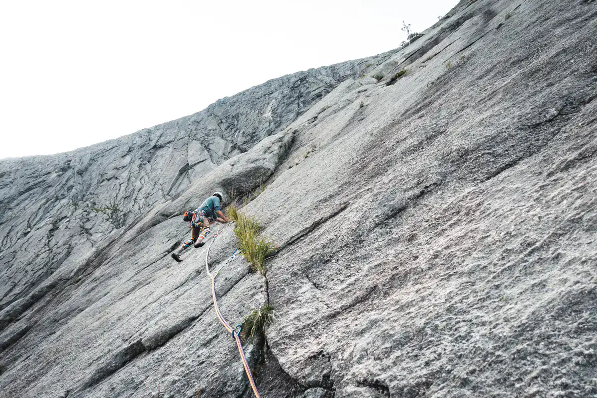 Kletterer am Seil in einer plattigen Granitwand in Norwegen