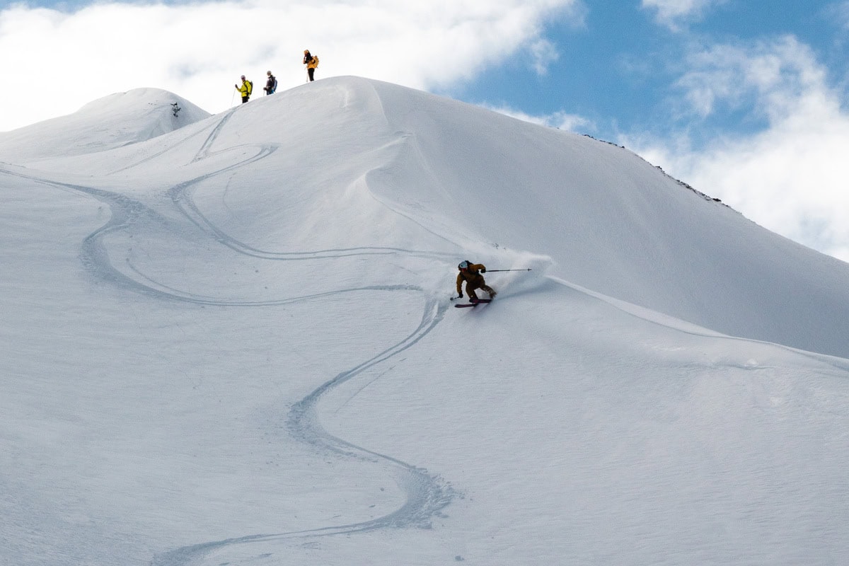 Skitourengeher in der Abfahrt durch unverspurten Pulverschnee