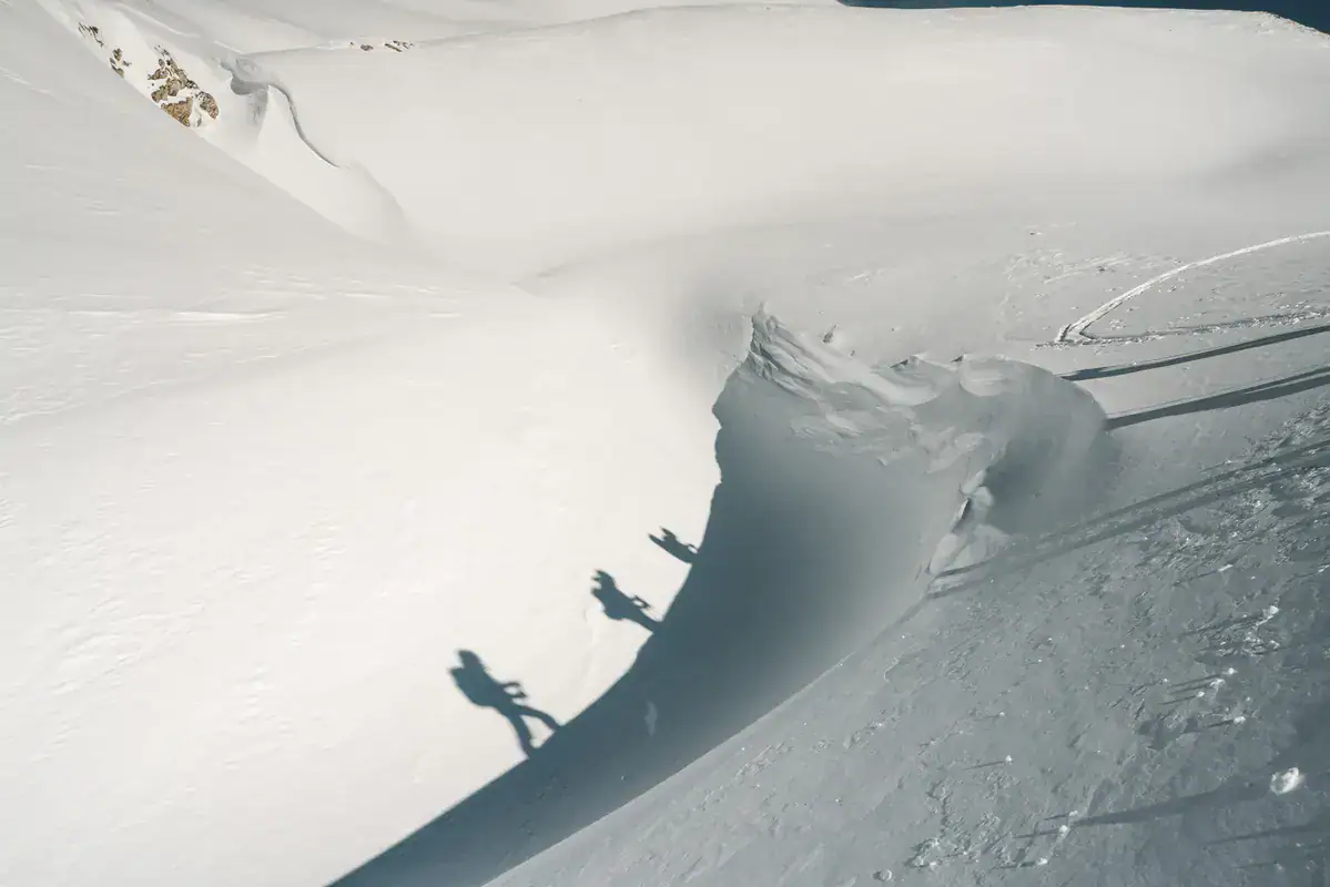 Schatten zweier Schneeschuhwanderer auf einem weiten Schneehang