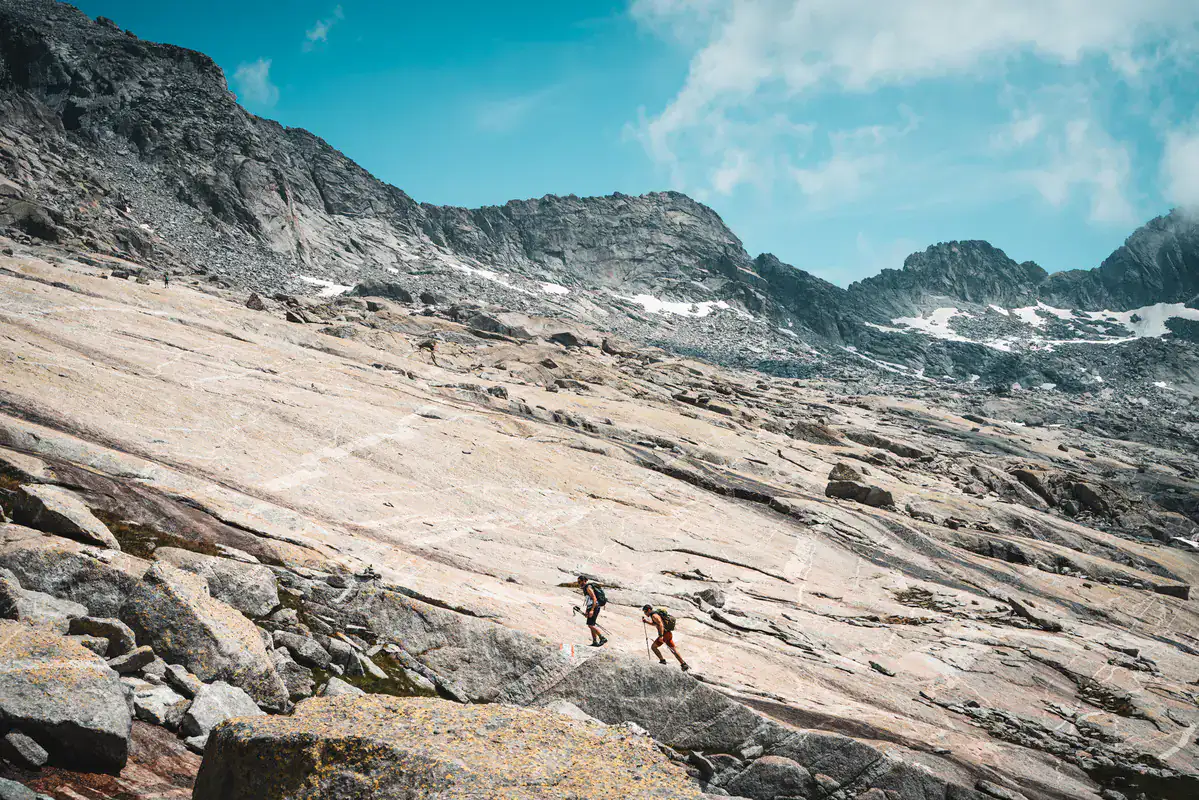Wanderer queren eine Granitplatten-Landschaft im Hochgebirge